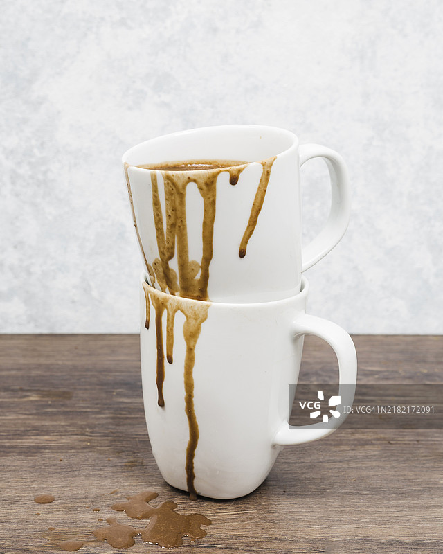 正面视角的脏杯子，咖啡洒出。图片素材