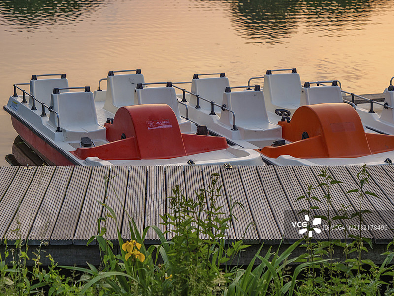 宁静湖泊边码头上的脚踏船特写，周围绿意盎然，位于德国明斯特地区的普罗布斯廷湖，博尔肯。图片素材