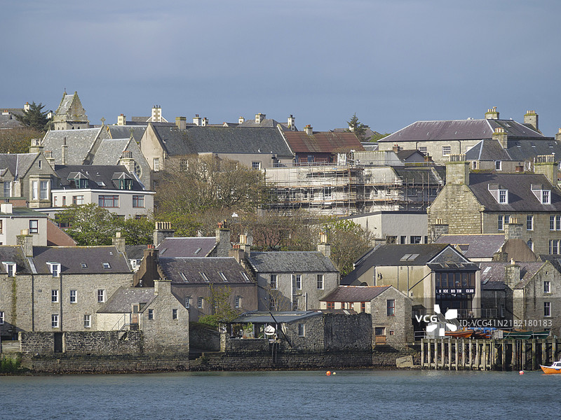 传统小镇的景观，水边的房屋和建筑，展示了苏格兰谢特兰群岛勒威克古老港口小镇的建筑风格。图片素材