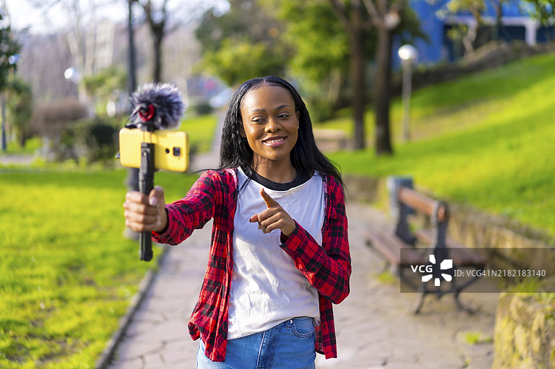 非洲女性在城市中用手机录制视频的正面照片图片素材
