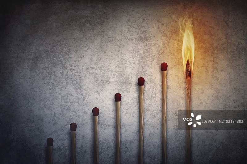 火柴棒排列成上升图形，顶部的火柴棒正在燃烧。金融图表隐喻背景，展示商业增长或领导力概念。图片素材
