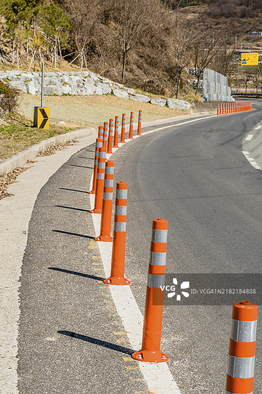 在韩国乡村弯曲道路旁的白线上的交通路桩图片素材