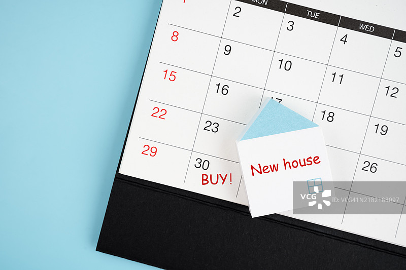 日历上用红色墨水写着“买”字。房屋房地产概念。图片素材