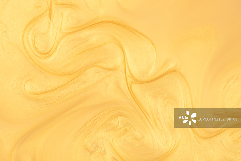 流动的闪光金色油漆波纹图案特写，全画幅视图，抽象金色背景。图片素材