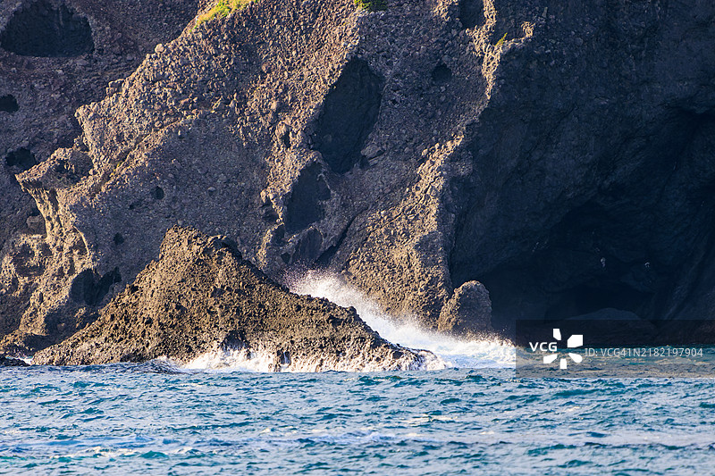平藏滨海滩的蓝色海洋，洁白的浪花拍打着礁石。一块看似要掉落但实际上并没有的権力岩。平藏滨海滩，南伊豆，中木，伊豆半岛，静冈县，日本。- 2024。图片素材