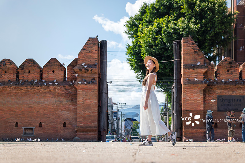 优雅的亚洲女性走过清迈的塔佩门图片素材