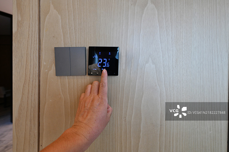 在控制面板上调整室内空调温度图片素材