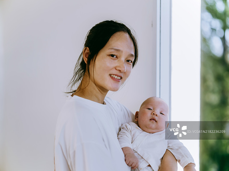 母亲抱着她的男婴的肖像图片素材