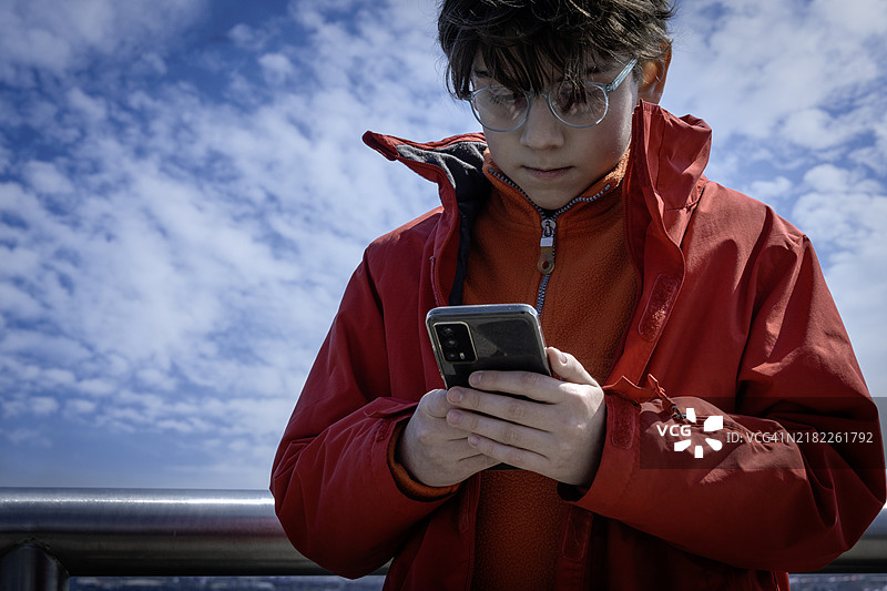 拿着手机的男孩。图片素材