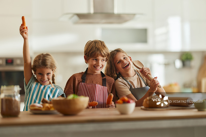 快乐的小孩子们在厨房里准备食物时玩得很开心。图片素材