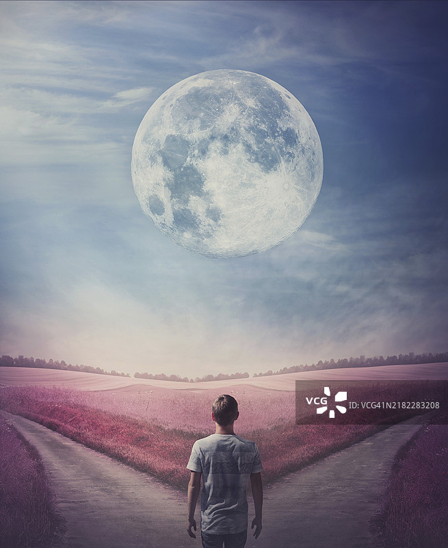 超现实的紫色世界，一个人跟随满月，来到一个十字路口，必须选择正确的道路，左边还是右边。果断选择的概念，分岔的道路有两个方向。图片素材
