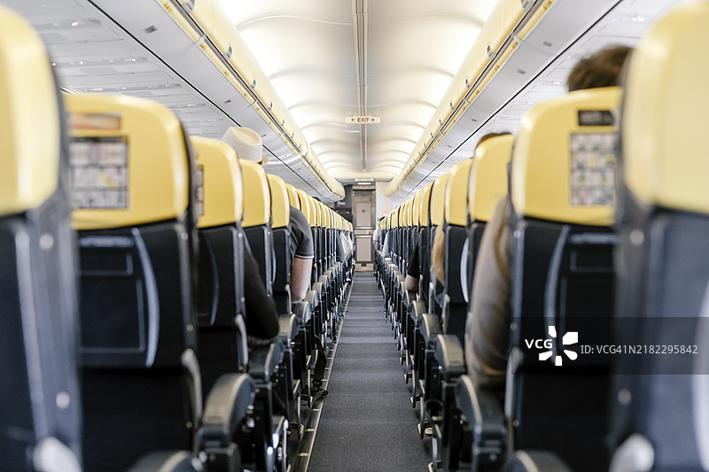 飞机上的空走廊，所有乘客都坐着。图片素材