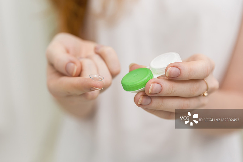 女人手中拿着隐形眼镜及其容器图片素材