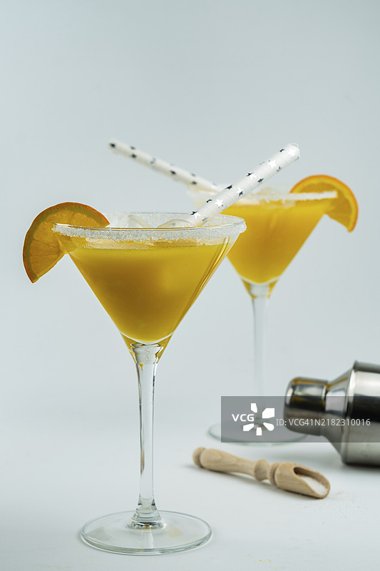新鲜榨取的天然橙子鸡尾酒，杯子底部放着一个摇酒器图片素材