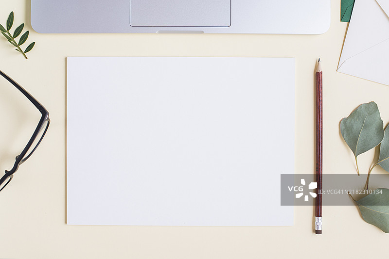 空白白纸、铅笔、眼镜、树叶、笔记本电脑、米色背景图片素材