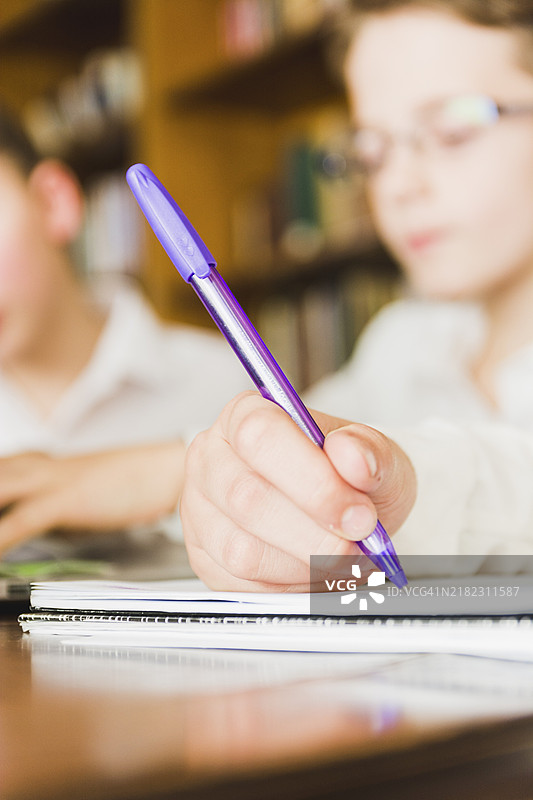 孩子的手在写学校的作业本图片素材