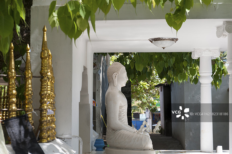 佛教，通德斯瓦拉姆寺，冥想，坐在绿色菩提树叶下的佛像，白色佛像，德维努瓦拉斯里毗湿奴大庙，位于马塔拉附近的东德拉，斯里兰卡南部，亚洲图片素材