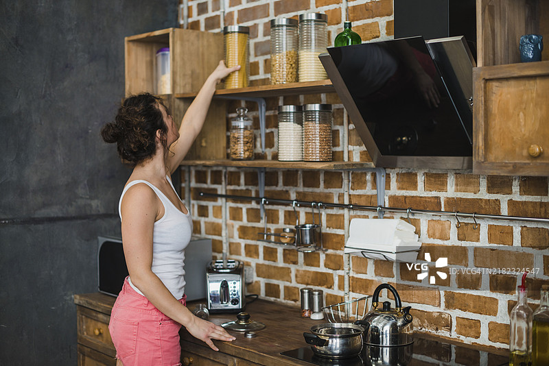 女人从架子上拿意大利面图片素材
