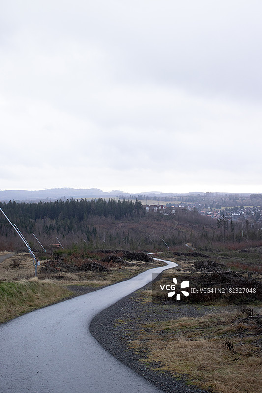 冬季全景，背景是山脉和小镇，前景是铺有沥青的道路和雪炮。图片素材
