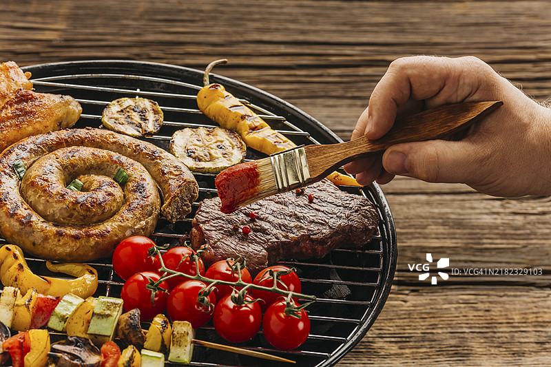 手持刷子为肉类腌制，准备烤制图片素材