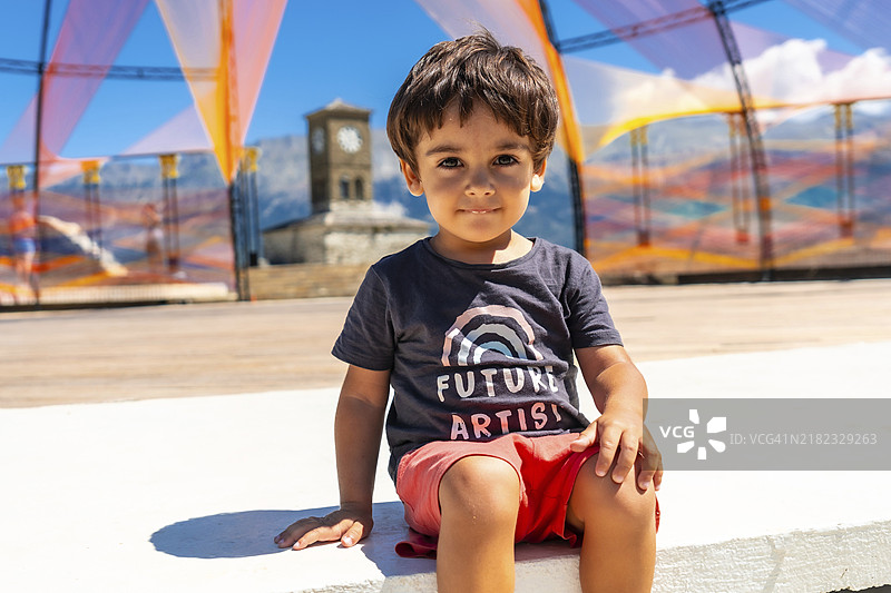 一个两岁男孩坐着享受暑假的肖像图片素材