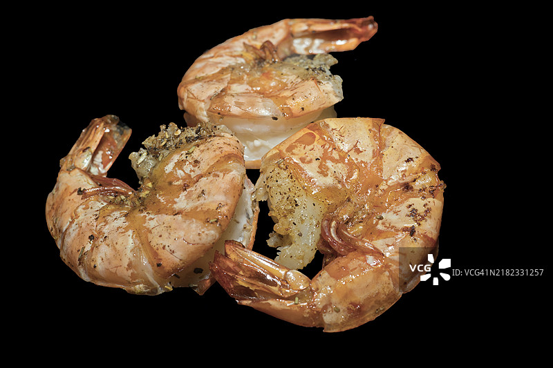 三只大型油炸大虾，黑虎虾（Penaeus monodon），黑色背景的美食摄影图片素材