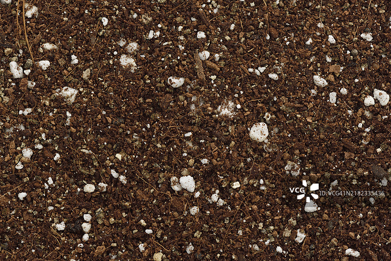 椰子纤维、蛭石和珍珠岩的无土栽培基质或育苗混合土，用于园艺和种植，替代土壤。白色背景下孤立的锥形堆的特写。图片素材