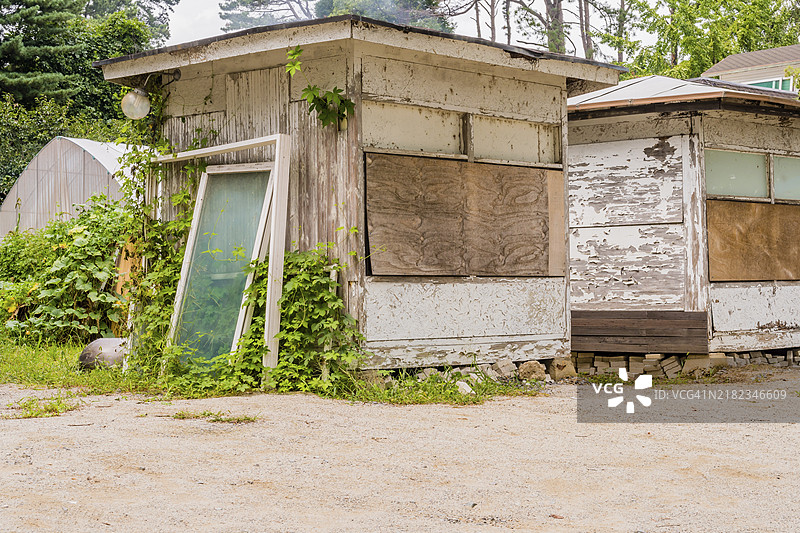 废弃的湖边小屋，前景是碎石停车场图片素材