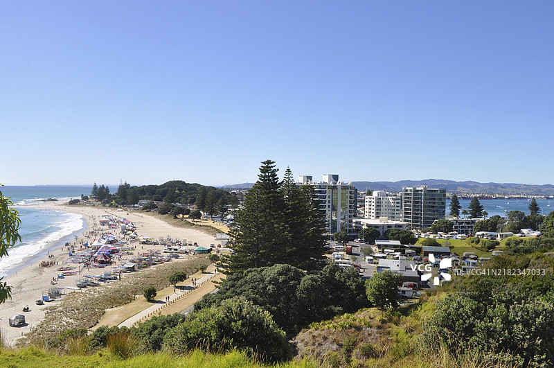 一群人享受新西兰奥克兰塔朗加海滩的冲浪乐趣图片素材