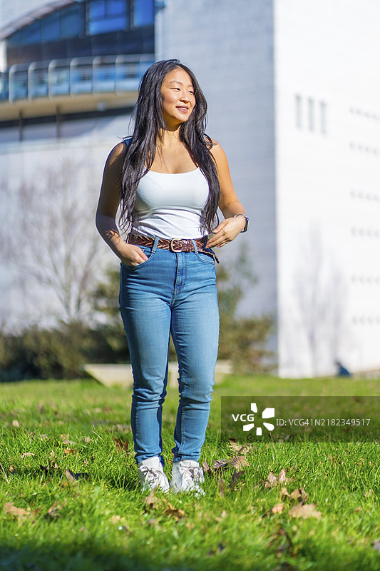 校园草地上站着的帅气中国学生的竖版照片图片素材