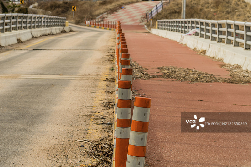 旧废弃桥中央的一排交通路障，焦点在第一个路障上，背景模糊。图片素材
