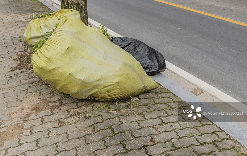 韩国路边的绿袋和黑色塑料袋装有垃圾图片素材