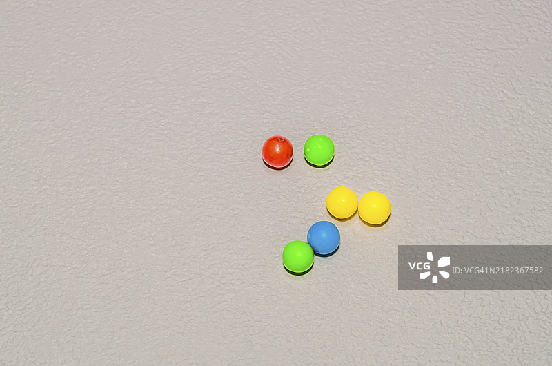 粉色纹理背景上的小圆形糖果特写图片素材