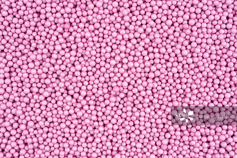 粉色泡沫珠或聚苯乙烯球的特写纹理作为背景。图片素材