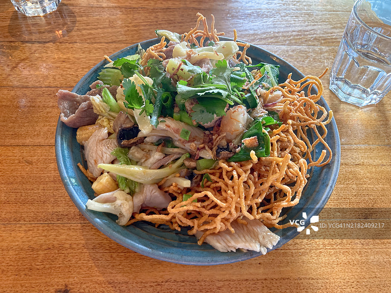 金黄酥脆的蛋面炒牛肉、鸡肉、虾和蔬菜的拼盘图片素材