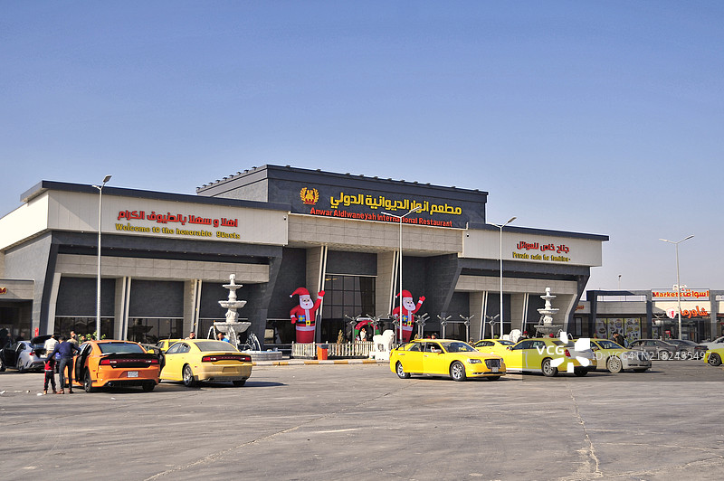 旅行者在伊拉克纳西里亚至巴士拉的高速公路服务区停留。图片素材