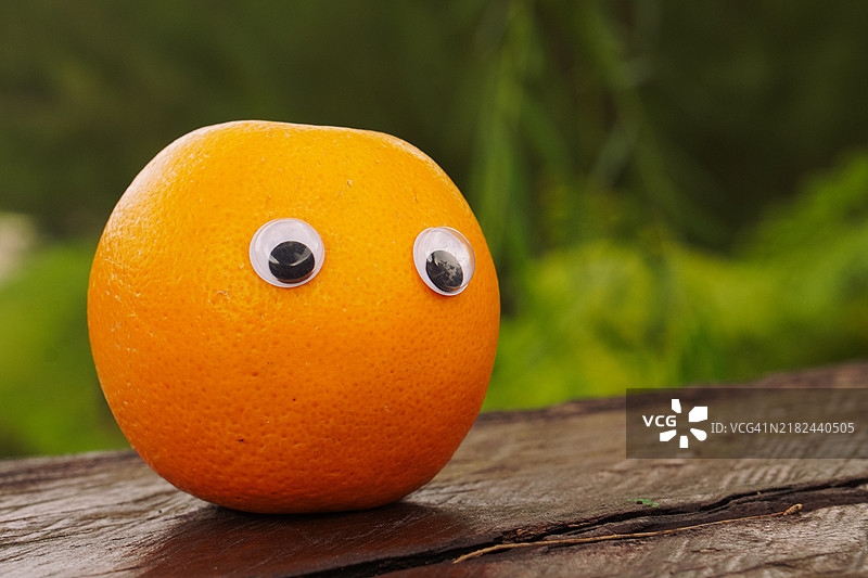 带表情符号的橙子放在粗糙的木桌上图片素材
