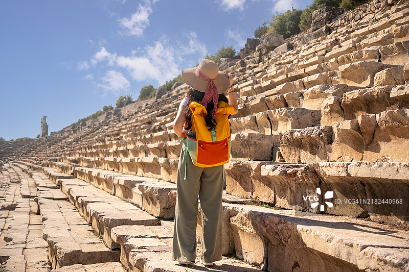 美丽的摄影师女孩正在欣赏古代吕基亚城市基比拉（Kibyra, Cibyra）的体育场。图片素材