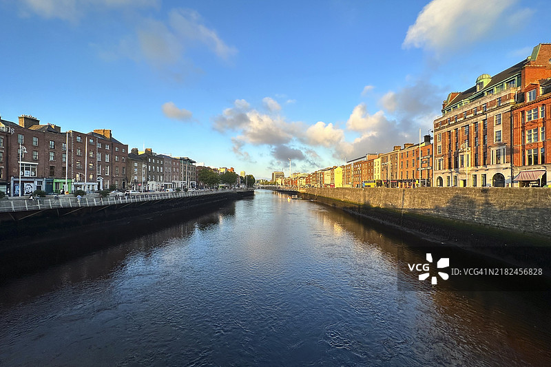 都柏林，爱尔兰，欧洲，蓝天白云下的河流与邻近的砖砌建筑景观图片素材