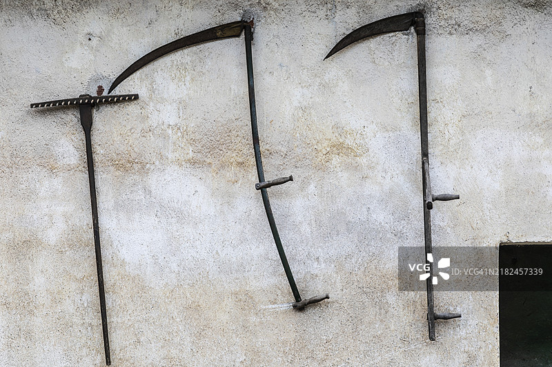 奥地利施蒂利亚州尼克拉斯多夫的房屋外立面上的镰刀和耙子图片素材