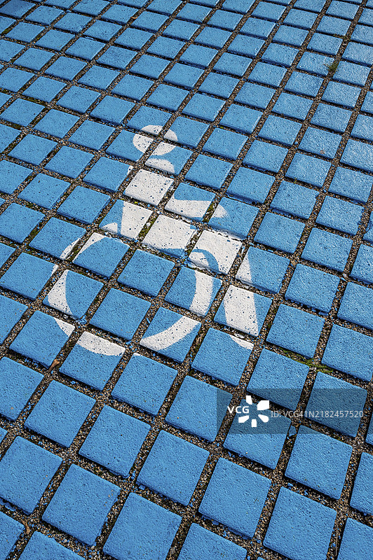 停车场预留，残疾人图标，蓝色人行道上的轮椅使用者图标，德国巴伐利亚州阿尔戈伊的肯普滕，欧洲图片素材