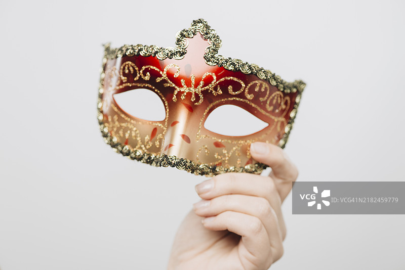 女人手持红色狂欢节面具图片素材