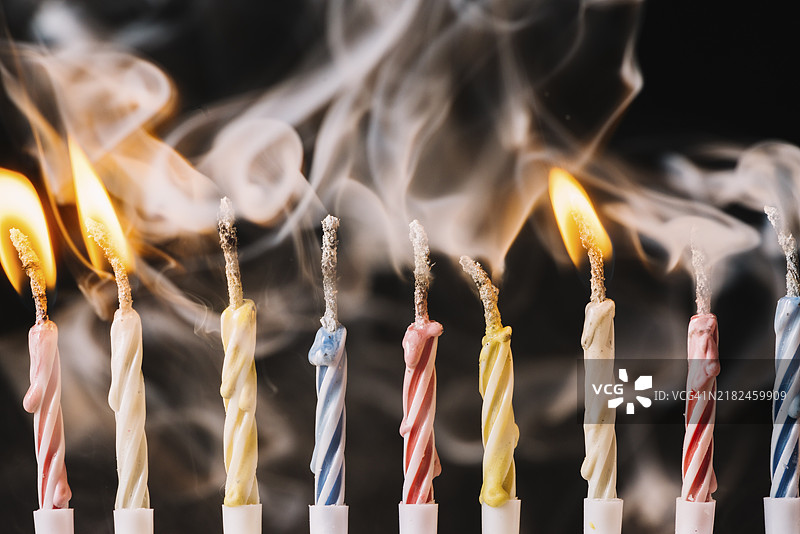 黑色背景下熄灭的燃烧蜡烛图片素材