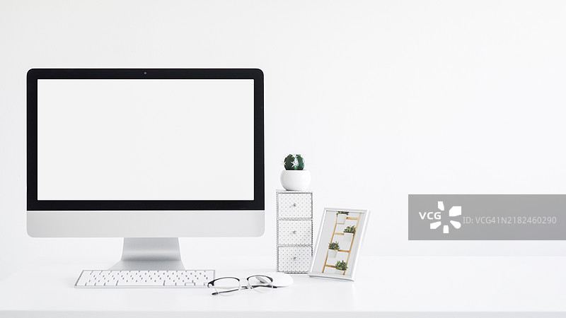 键盘靠近显示器框架、仙人掌、眼镜和桌子图片素材