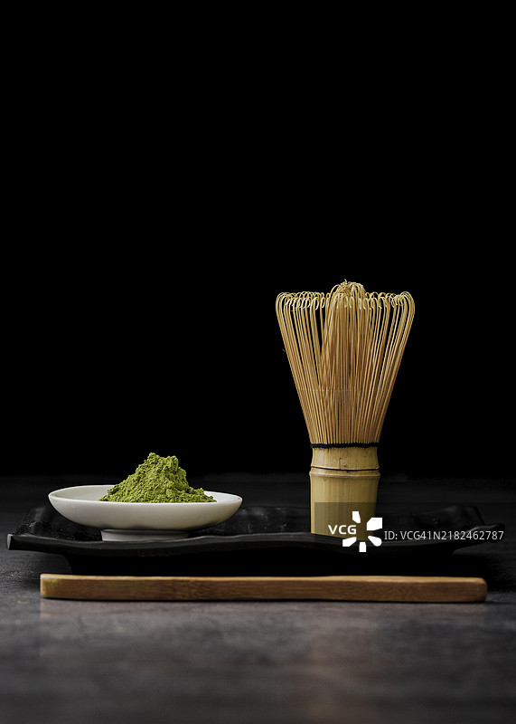 正面视角的抹茶粉与竹制打 whisk图片素材