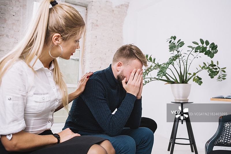 美丽的女性心理学家在诊所安慰她的男性抑郁患者图片素材