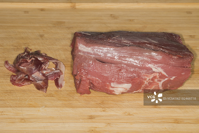 去掉银皮的牛肉里脊放在竹制砧板上图片素材