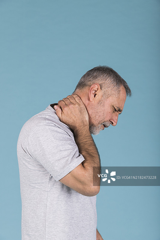侧面视角的成熟男性正在遭受颈部疼痛图片素材