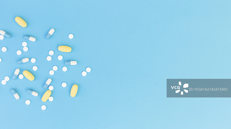 顶部视角的药丸胶囊，蓝色背景图片素材
