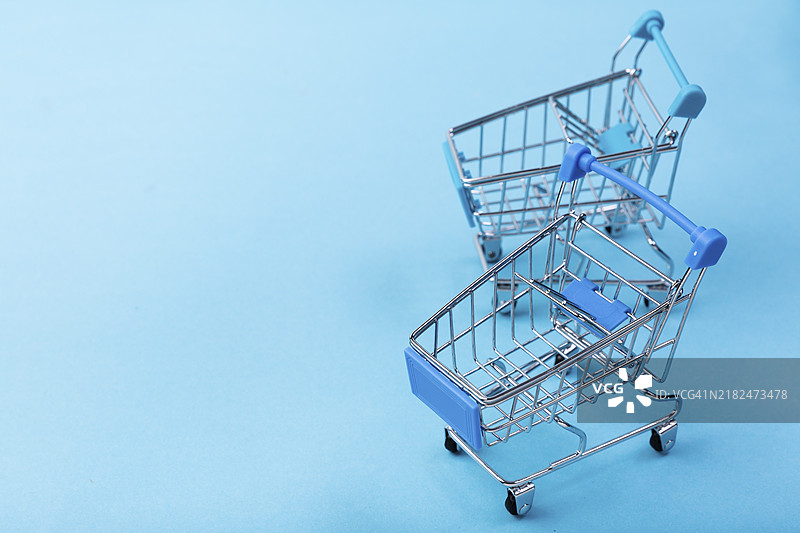蓝色背景的购物车，留有空白空间图片素材